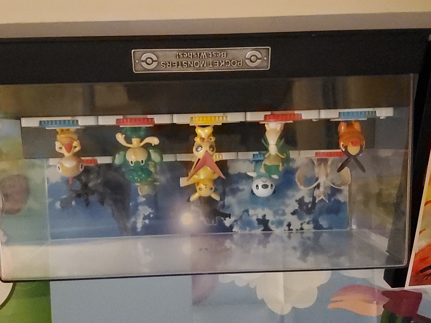 ten pokemon figures in a plastic box case labeled BEST WISHES. reshiram, oshawott, pikachu, axew, zekrom, tepig, snivy, victini, pansage, and scraggy