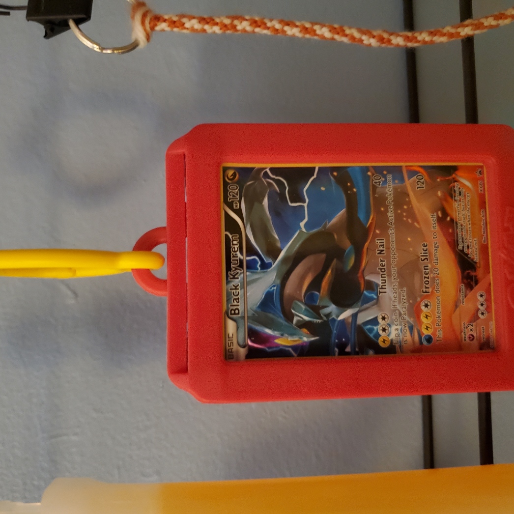 red and yellow pokemon card holder featuring black kyurem card