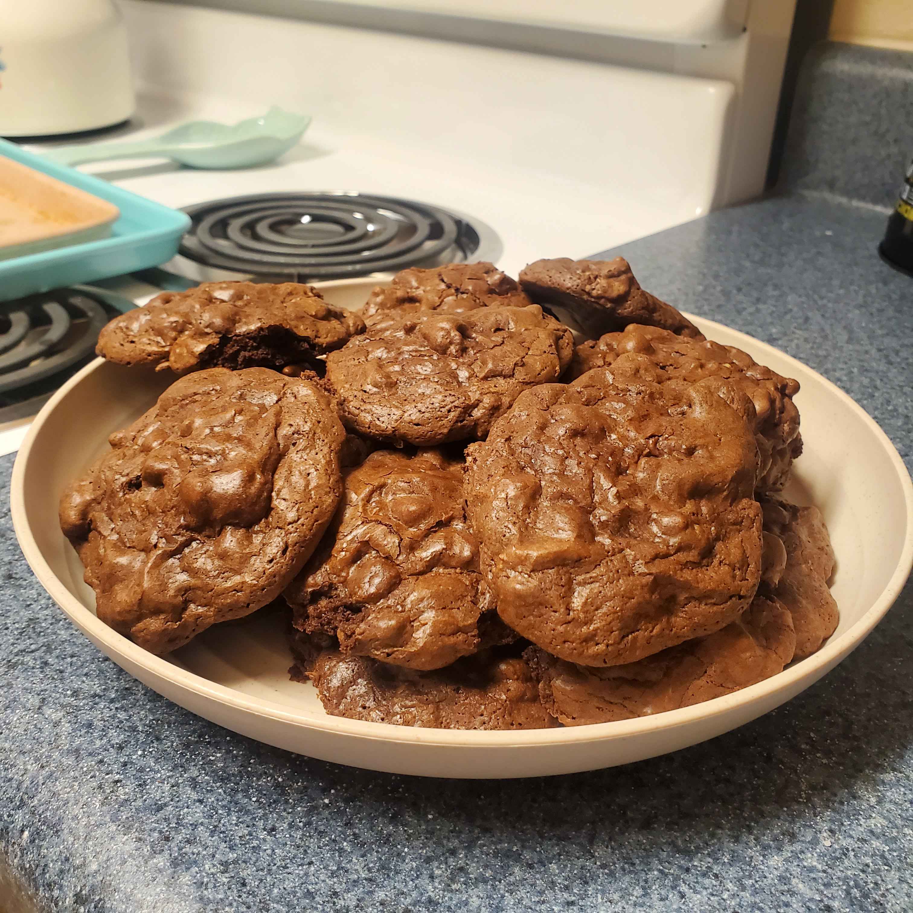 three brown, lumpy chocolate cookies on a pan